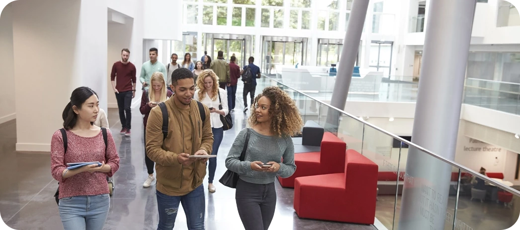 Étudiants se déplaçant dans le hall lumineux d’un campus universitaire