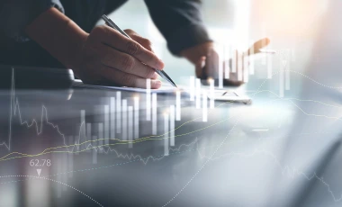 Personne analysant des données et graphiques financiers sur un bureau